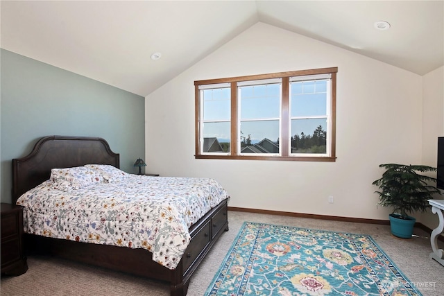 bedroom with light colored carpet, baseboards, and vaulted ceiling