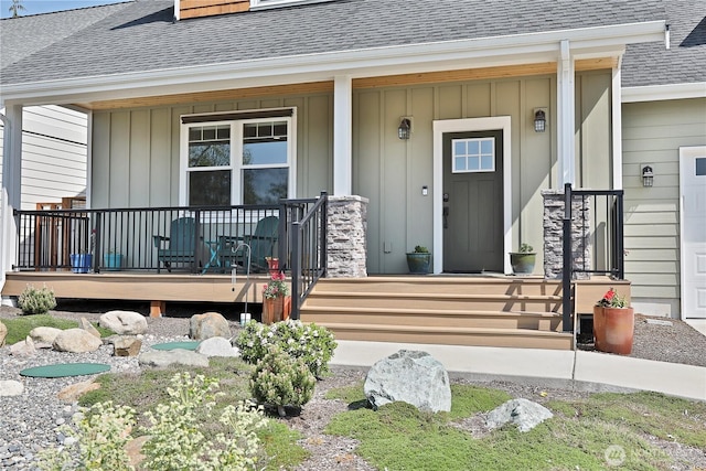 entrance to property with board and batten siding, roof with shingles, and covered porch