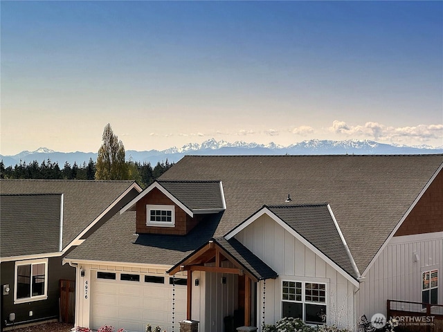 view of front facade featuring an attached garage, board and batten siding, and a mountain view