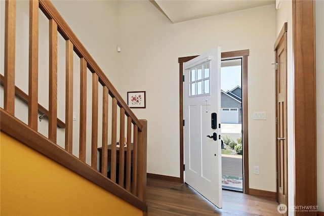 entrance foyer with baseboards, wood finished floors, a wealth of natural light, and stairway
