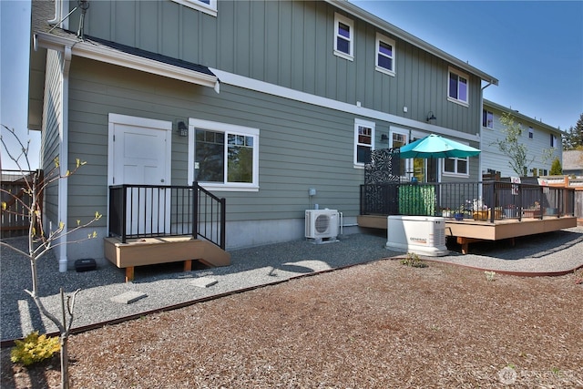 back of house featuring ac unit, board and batten siding, and a deck