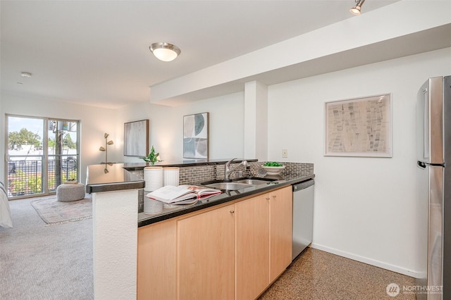412 11th Ave Unit 309, Seattle, WA 98122 - kitchen with dark countertops, a sink, light brown cabinets, stainless steel appliances, and a peninsula