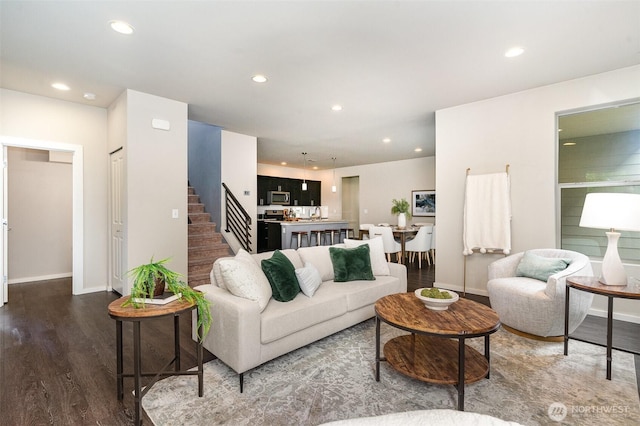 living area with recessed lighting, stairway, baseboards, and dark wood-style flooring