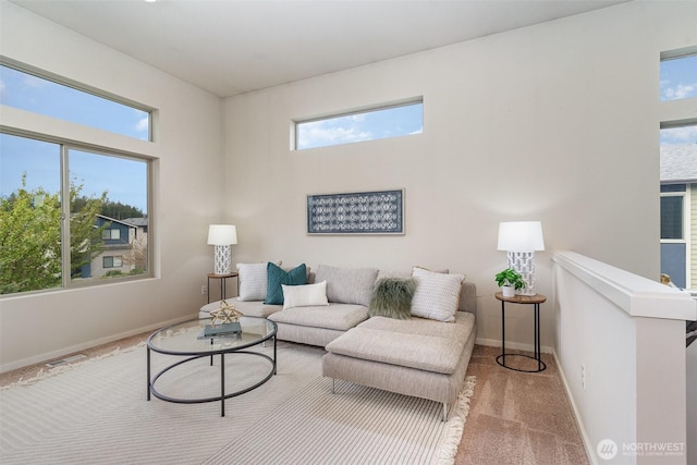 carpeted living area featuring plenty of natural light and baseboards