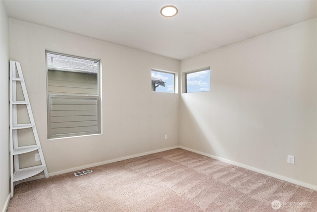 carpeted spare room featuring baseboards