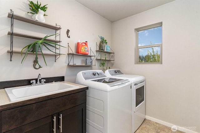 laundry area with cabinet space, washing machine and dryer, baseboards, and light tile patterned floors