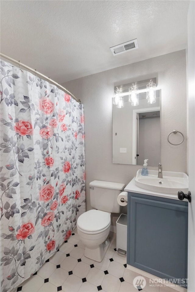 bathroom with vanity, a textured ceiling, toilet, and a shower with curtain