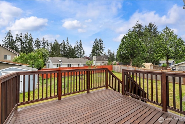 deck featuring a storage unit, an outbuilding, and a residential view