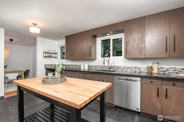 kitchen featuring dark tile patterned floors, a sink, and dishwasher
