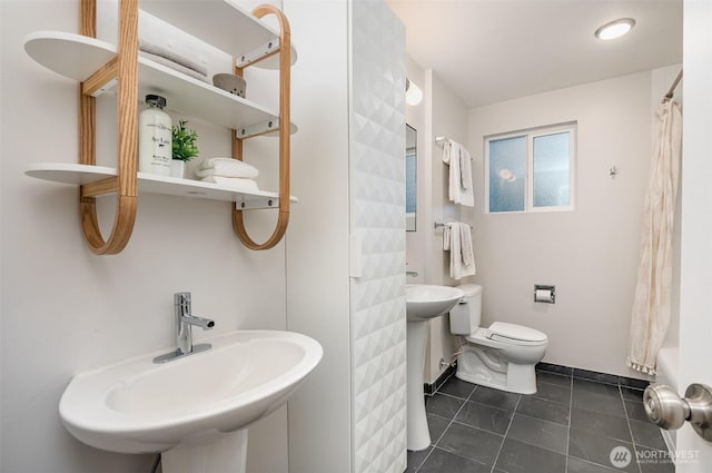 full bath featuring toilet, a shower with curtain, a sink, and tile patterned floors