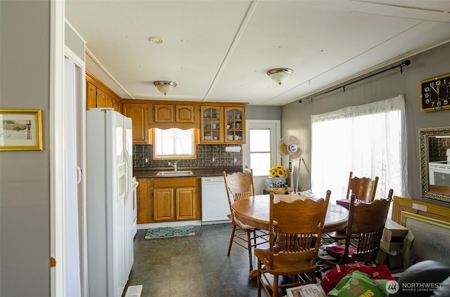 kitchen with a wealth of natural light, white appliances, a sink, and brown cabinets