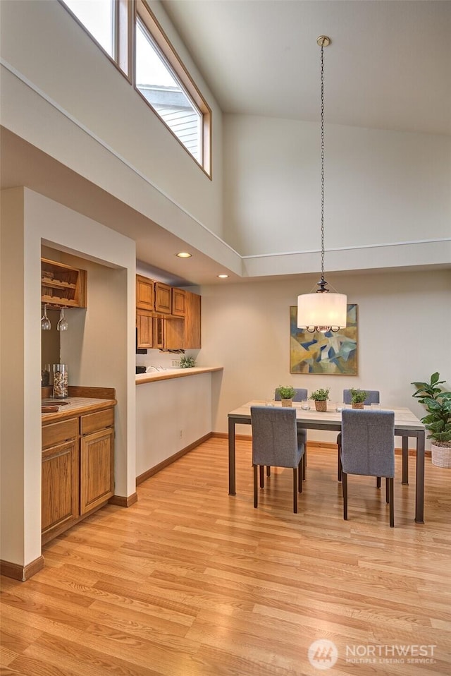 909 N 35th St Unit 402, Seattle, WA 98103 - dining area with light wood-type flooring, recessed lighting, baseboards, and a towering ceiling