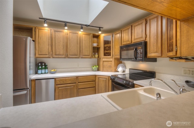 909 N 35th St Unit 402, Seattle, WA 98103 - kitchen with open shelves, track lighting, a sink, light countertops, and black appliances