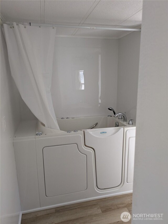 laundry room with wood finished floors and a textured ceiling
