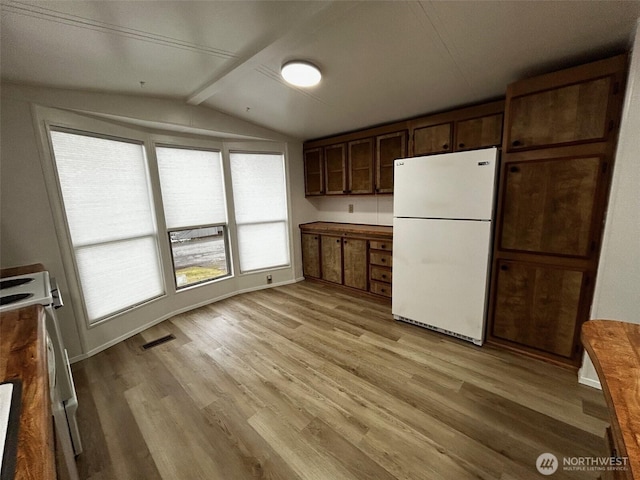 kitchen featuring lofted ceiling, visible vents, freestanding refrigerator, light wood-style flooring, and electric range
