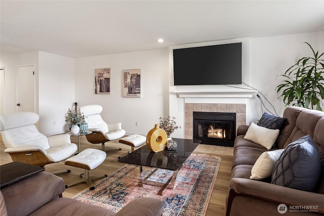 living area with a tiled fireplace, wood finished floors, and recessed lighting
