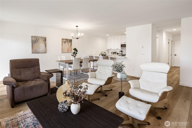 living room with recessed lighting, light wood finished floors, and an inviting chandelier