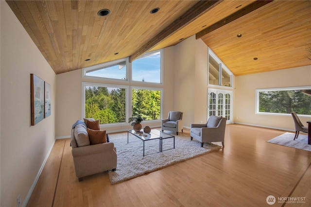 living area featuring baseboards, wood finished floors, beam ceiling, and wood ceiling