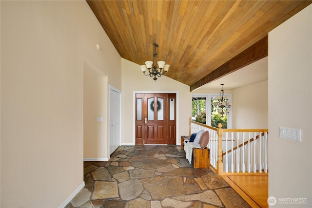 entrance foyer featuring baseboards, an inviting chandelier, wooden ceiling, and stone finish flooring