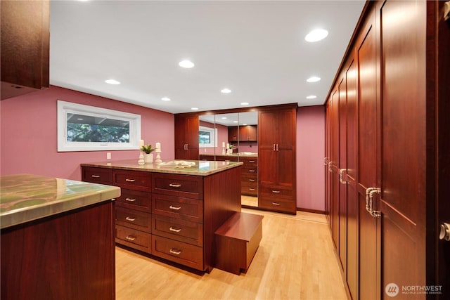 kitchen featuring recessed lighting, pendant lighting, reddish brown cabinets, and light wood-style floors