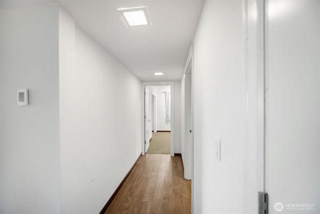 hallway featuring baseboards and dark wood-type flooring