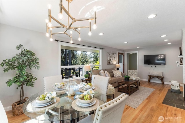 dining room with wood finished floors, baseboards, recessed lighting, and a chandelier
