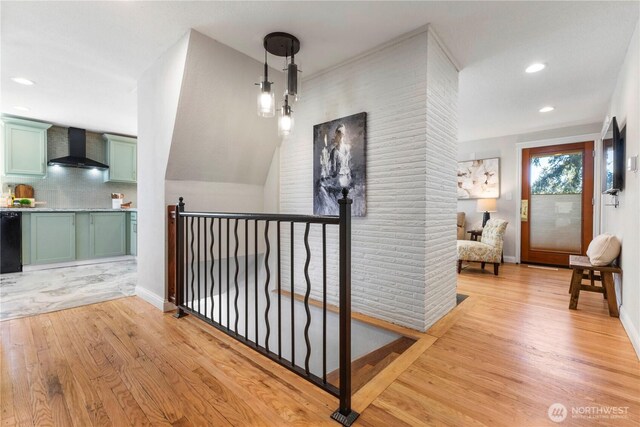 hall featuring light wood-style floors, recessed lighting, an upstairs landing, and baseboards