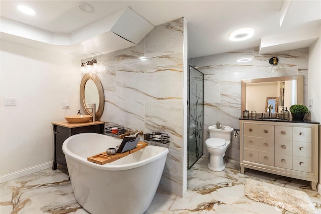 full bathroom with tile walls, marble tiled flooring, a soaking tub, and two vanities