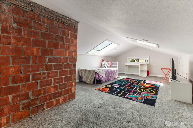 bedroom featuring a skylight, carpet floors, vaulted ceiling, and a textured ceiling