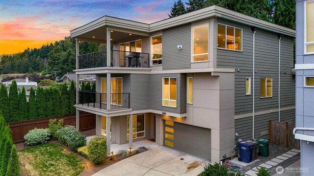 4888 194th Ave SE, Issaquah, WA 98027 - contemporary house featuring a garage, concrete driveway, a balcony, and fence