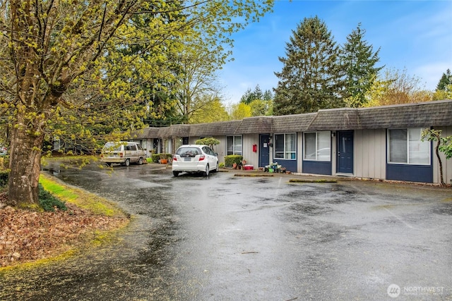 ranch-style home with uncovered parking and mansard roof