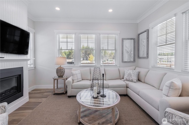 living area with a large fireplace, recessed lighting, and ornamental molding