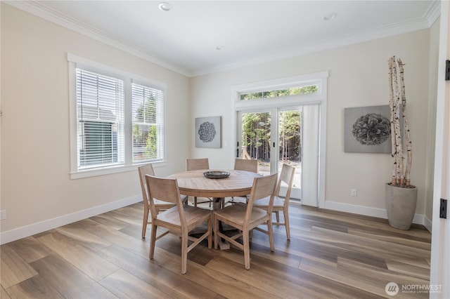 dining space with baseboards, ornamental molding, french doors, and light wood finished floors