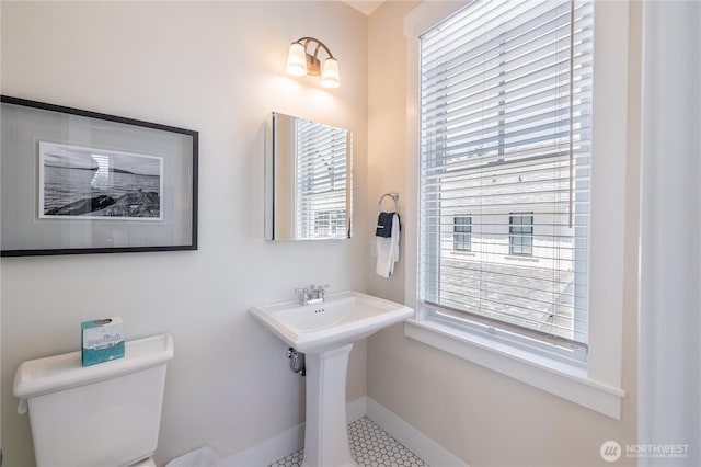 bathroom featuring toilet and baseboards