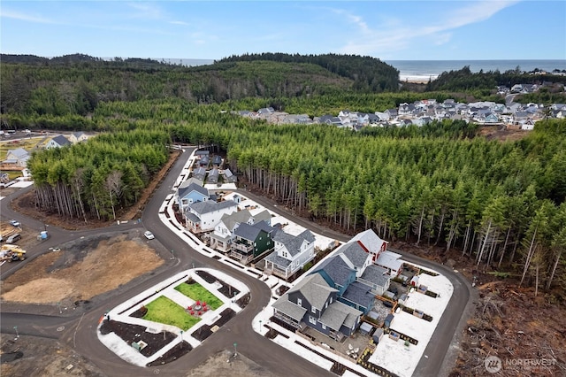 birds eye view of property with a forest view, a water view, and a residential view