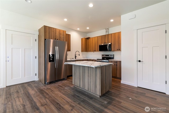 4226 Melrose Ln, Bellingham, WA 98226 - kitchen with stainless steel appliances, brown cabinetry, a sink, a kitchen island, and dark wood-style flooring