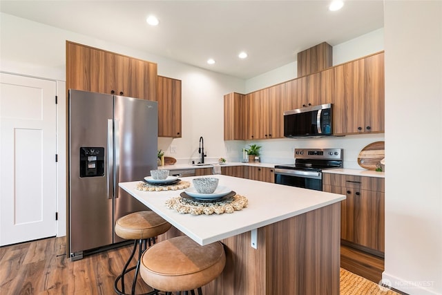 4226 Melrose Ln, Bellingham, WA 98226 - kitchen featuring appliances with stainless steel finishes, a kitchen breakfast bar, light countertops, wood finished floors, and recessed lighting