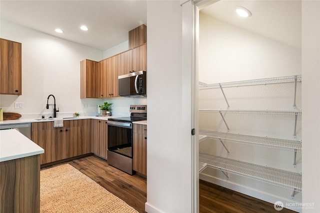 4226 Melrose Ln, Bellingham, WA 98226 - kitchen featuring appliances with stainless steel finishes, dark wood-style flooring, light countertops, recessed lighting, and brown cabinets