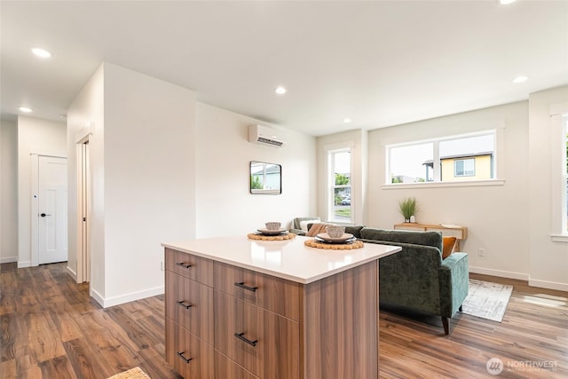 4226 Melrose Ln, Bellingham, WA 98226 - kitchen featuring wood finished floors, a wall unit AC, a center island, recessed lighting, and modern cabinets