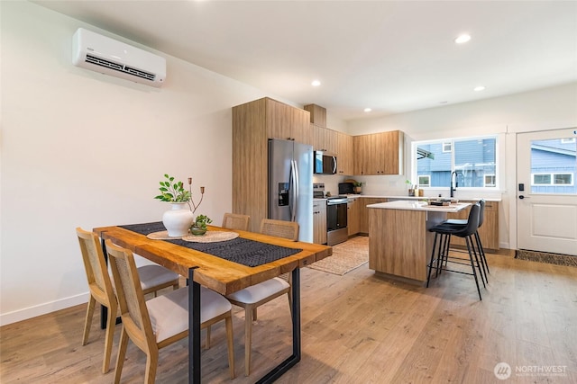 4228 Melrose Ln, Bellingham, WA 98226 - kitchen featuring stainless steel appliances, an AC wall unit, a center island, light countertops, and a breakfast bar
