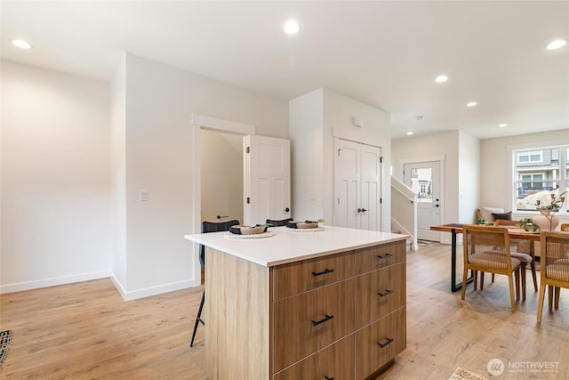 4228 Melrose Ln, Bellingham, WA 98226 - kitchen featuring light wood-type flooring, a center island, recessed lighting, modern cabinets, and a breakfast bar area