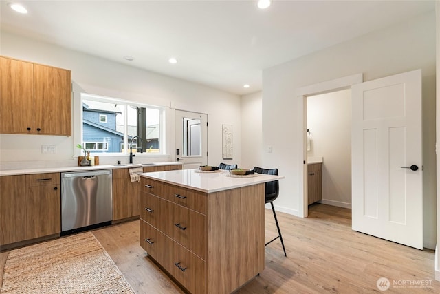 4228 Melrose Ln, Bellingham, WA 98226 - kitchen with dishwasher, a breakfast bar area, a center island, light wood-style flooring, and light countertops