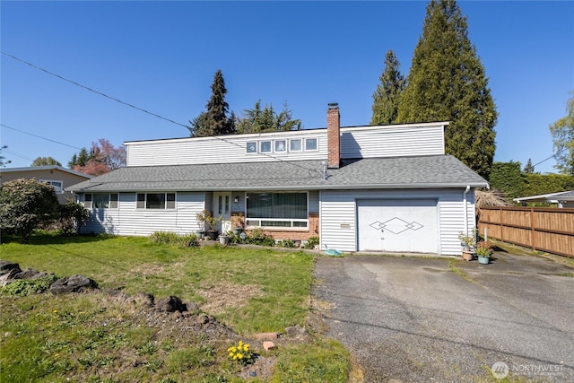 traditional-style home with driveway, a chimney, an attached garage, fence, and a front lawn