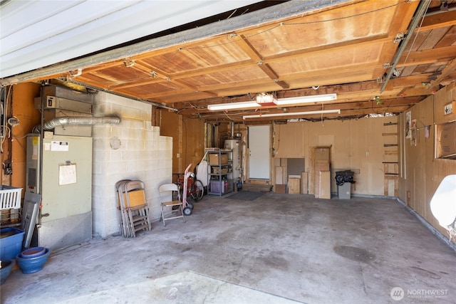 garage with gas water heater and a garage door opener