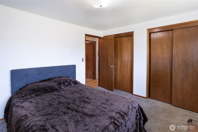 bedroom with carpet flooring and two closets