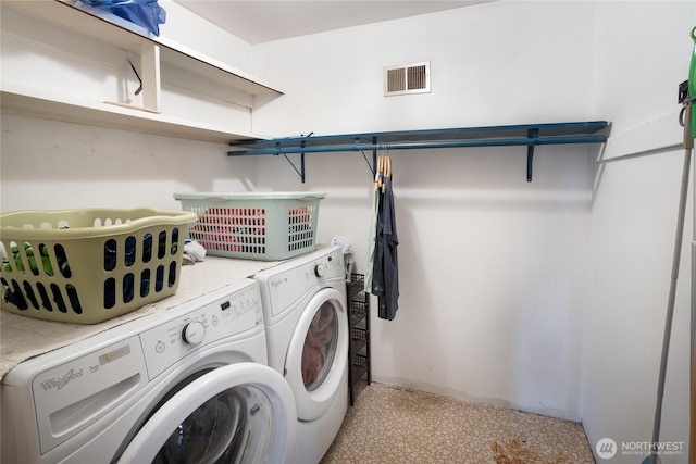 washroom with washer and dryer, visible vents, and laundry area