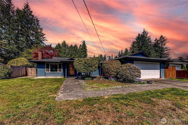 view of front of property featuring a garage, fence, driveway, and a front lawn