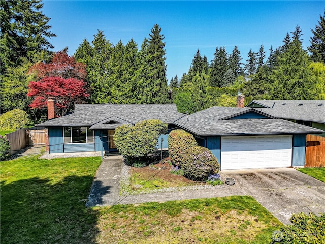 ranch-style home with a garage, fence, and a chimney