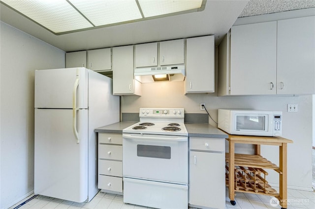 kitchen with white appliances, under cabinet range hood, and light countertops