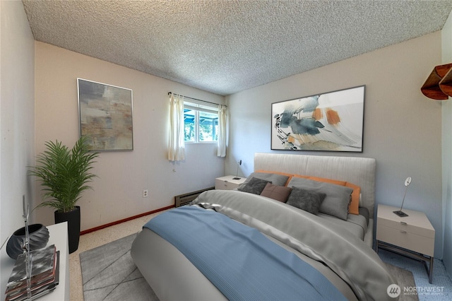 carpeted bedroom featuring a textured ceiling and baseboards